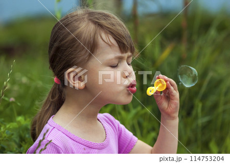 Portrait of cute lovely little girl blowing soap bubbles 114753204