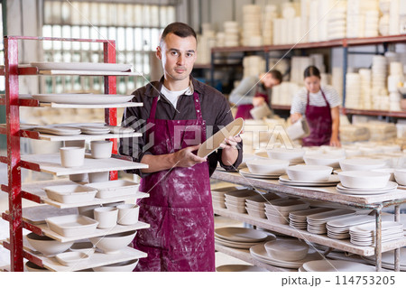 Young man posing with ceramic blanks 114753205
