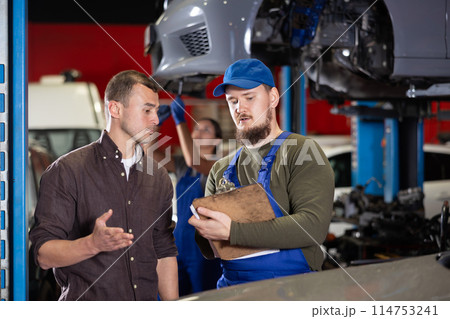 Mechanic guy signs agreement with young man client 114753241