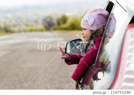 Pretty little girl in the car looking through car window. Travel concept. 114753290