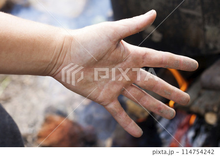 Close-up view of white woman dirty sandy hand palm with spread fingers on blurred colorful sunny outdoors background. Gardening, householding work and labor concept. Close-up view of white woman dirty sandy hand palm with spread fingers on blurred colorful sunny outdoors background. Gardening, householding work and labor concept. 114754242