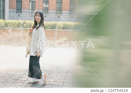 休日に都会を一人歩きする若い女性 114754329