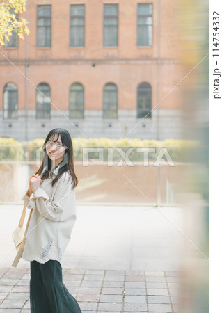 休日に都会を一人歩きする若い女性 114754332