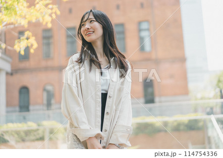 休日に都会を一人歩きする若い女性 休日に都会を一人歩きする若い女性 114754336