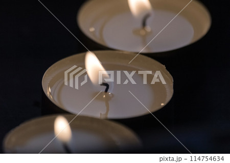 Three candles on a black background. Shallow depth of field. Three candles on a black background. Shallow depth of field. 114754634