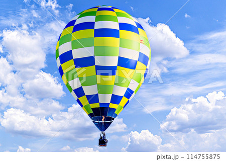 Colorful hot air balloon flying over blue sky with white clouds Colorful hot air balloon flying over blue sky with white clouds 114755875