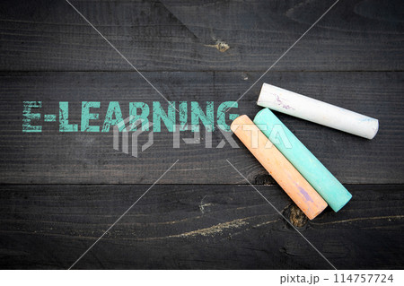 E-Learning Concept. Text and pieces of chalk on a dark wood texture backgroun 114757724