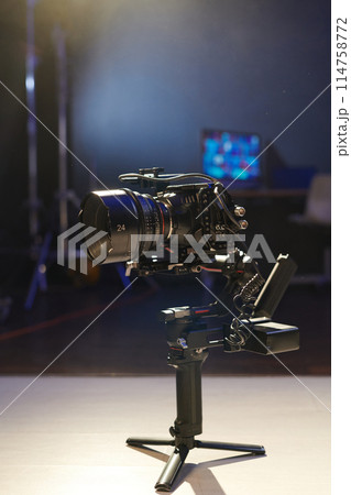 Vertical background image of pro digital camera on stabilizer stand in studio 114758772