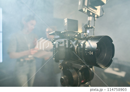 Background image of professional digital video camera on stand in video production studio with smoke effect copy space Background image of professional digital video camera on stand in video production studio with smoke effect copy space 114758903