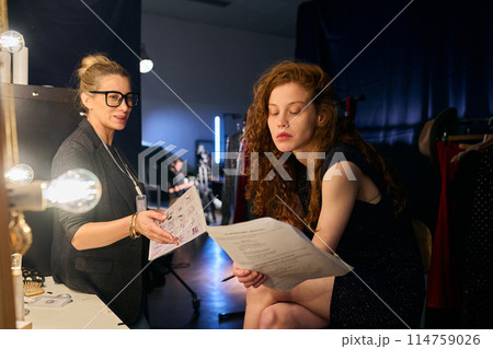 Portrait of female director and actress practicing script lines backstage in theater copy space Portrait of female director and actress practicing script lines backstage in theater copy space 114759026