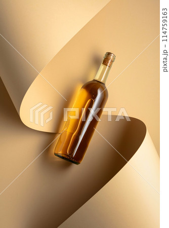 Bottle of white wine on a beige background. 114759163