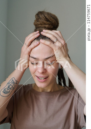 Vertical closeup portrait of emotional young woman with long dreadlocks trying to calm down Vertical closeup portrait of emotional young woman with long dreadlocks trying to calm down 114759671