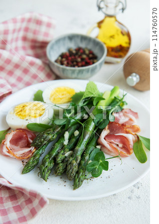 Fresh Asparagus and Prosciutto Salad Served With Boiled Eggs and Microgreens 114760570