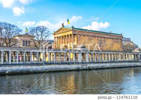 A serene view of the Old National Gallery located along the riverbank in Berlin, with classical architecture and clear skies. Germany 114761110