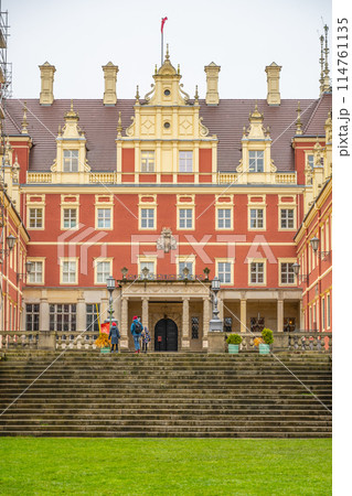The front view of Chateau Bad Muskau, with visitors on the entrance steps, under a grey, overcast sky. Saxony, Germany 114761135