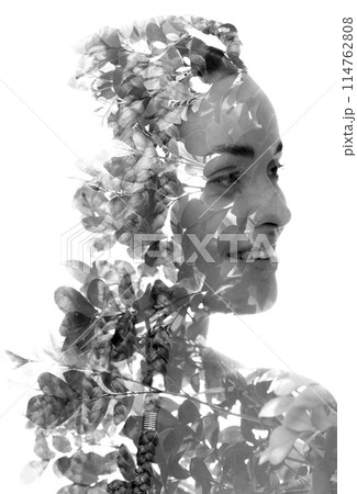 A smiling young woman's portrait merged with tree leaves in double exposure A smiling young woman's portrait merged with tree leaves in double exposure 114762808