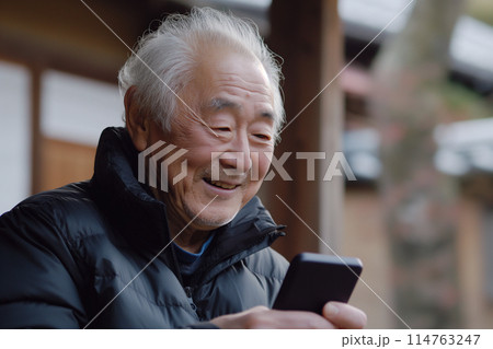 笑顔でスマホを操作するシニア男性 114763247