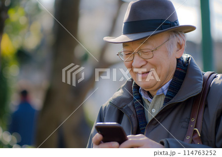 笑顔でスマホを操作するシニア男性 114763252