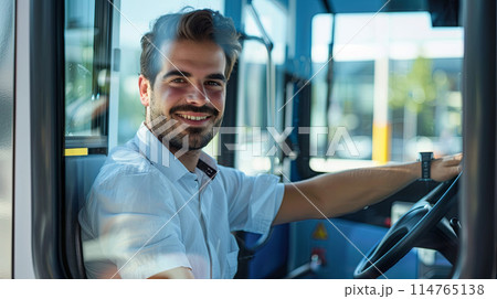handsome young tram driver sitting behind the wheel and smiles 114765138