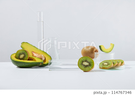 Front view of a glass podium in rectangle shaped displayed with halves of avocado and kiwi slices. Laboratory glassware featured. Liquid purification in the laboratory 114767346