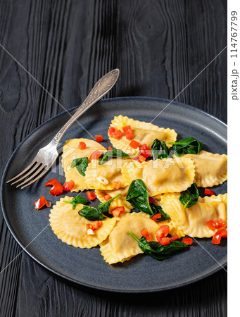 italian pasta mezzelune on a plate, top view 114767799