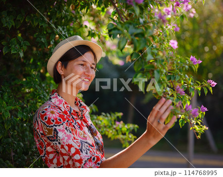 young woman stands in sunny green park young woman stands in sunny green park 114768995
