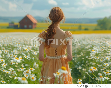 A woman in a summer dress runs through a field of daisies, laughing. 114769532
