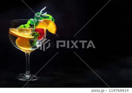 Fancy cocktail with fresh fruit. Gin and tonic drink with ice at a party Fancy cocktail with fresh fruit. Gin and tonic drink with ice at a party 114769914