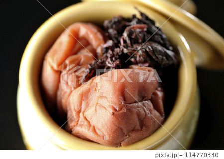 壺に入ってる梅干しと赤紫蘇を黒背景で俯瞰で撮影 114770330