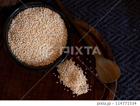Grais of quinoa in black bowl ,some seeds on wooden board 114771534