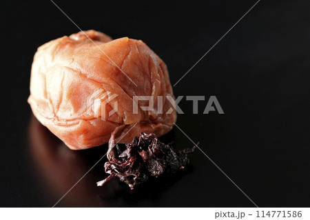 赤紫蘇と梅干しを黒背景に直置きで撮影 114771586