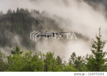Drone with camera flying over mountain fields. Drone with camera flying over mountain fields. 114772101