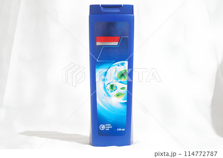 A blue bottle of shampoo with a blue cap 114772787