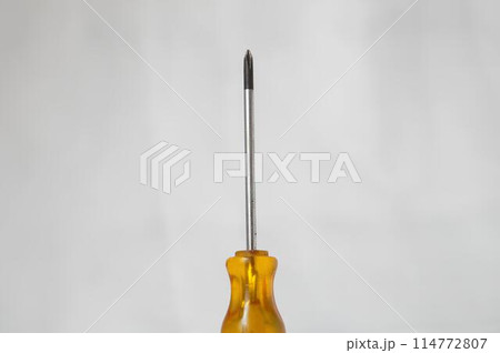 A yellow screwdriver with a silver tip A yellow screwdriver with a silver tip 114772807
