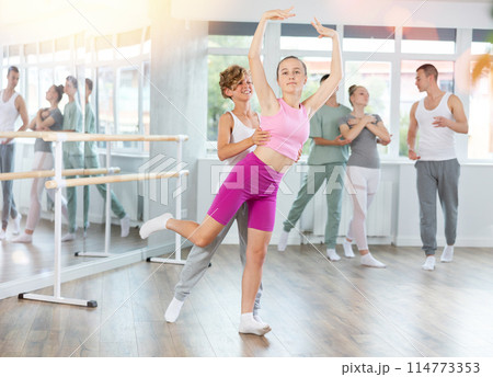 Boy and girl in pair train to perform ballet dance during rehearsal in studio Boy and girl in pair train to perform ballet dance during rehearsal in studio 114773353