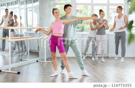 Boy and girl in pair train to perform ballet dance during rehearsal in studio 114773355