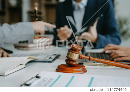 Teamwork of business lawyer meeting working hard about legal legislation in courtroom to help their customer. 114774445