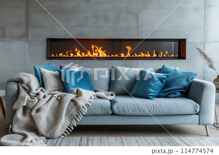 暖炉が埋め込まれたRC壁を背景に、グレーのソファセットが配置されたモダンなリビングルームのインテリア 114774574