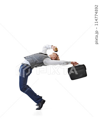 Dynamic Workday. Business professional bends backward, coffee in one hand and briefcase in other against white studio background. 114774892