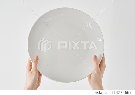 空のお皿を持つ女性の手元 114775663