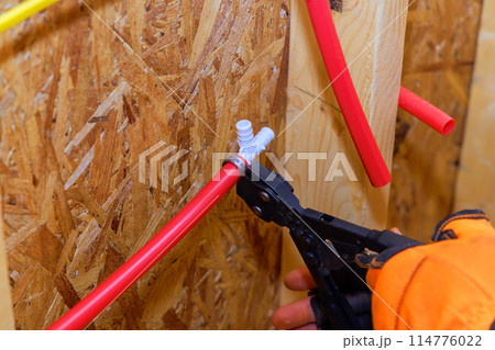 Plumbing installation connection to plastic PVC water pipes in wall 114776022