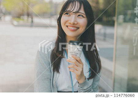 ホットコーヒーをテイクアウトした働く女性 ホットコーヒーをテイクアウトした働く女性 114776060