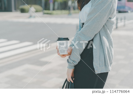 ホットコーヒーをテイクアウトした働く女性 ホットコーヒーをテイクアウトした働く女性 114776064