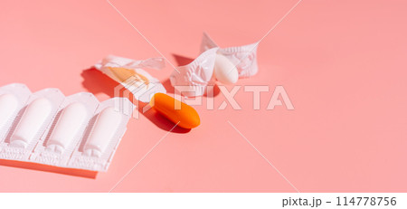 Rectal candles in packaging and unpacked on a pink background 114778756
