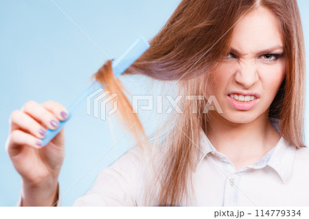 Long haired woman combing her hair. Long haired woman combing her hair. 114779334