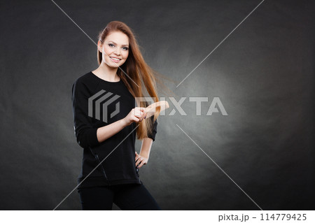 Long haired woman combing her hair. 114779425