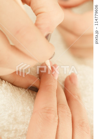 Beautician preparing nails before manicure, pushing back cuticles Beautician preparing nails before manicure, pushing back cuticles 114779606