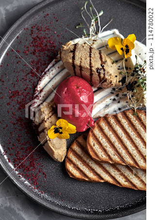 Duck paste with ice cream and grilled white bread croutons. Close-up, low key, gray background. Duck paste with ice cream and grilled white bread croutons. Close-up, low key, gray background. 114780022