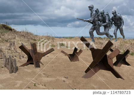 Normandy France D-Day soldiers sculptures and hedgehogs photomontage at WWII Utah Beach. Veterans Day rememberance. High quality photomontage Normandy France D-Day soldiers sculptures and hedgehogs photomontage at WWII Utah Beach. Veterans Day rememberance. High quality photomontage 114780723