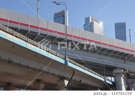 Overpasses on the background of skyscrapers. Blue sky and bright sun. Transport interchanges 114781159